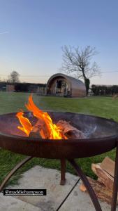 a fire pit with flames in it in a field at Millview Meadow Retreats in Great Yarmouth