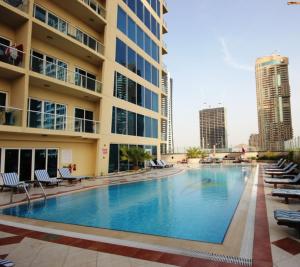 a large swimming pool in front of a building at Modern & Spacious 2-Bed Condo with Panoramic Lake Views, Dual Balconies, Steps from Dubai JLT Metro By "La Buena Vida Holiday Homes" in Dubai