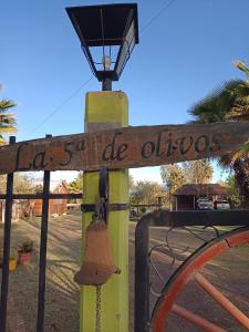 un cartel de madera en un poste con luz de la calle en Quinta Los Olivos en Maipú