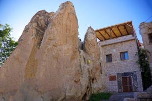 a building in front of a large rock at Saliche Cave Suite in Nevşehir