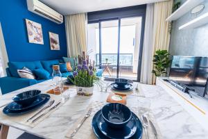 une salle à manger avec des murs bleus et une table avec des plats bleus dans l'établissement Arcoris Mont Kiara next 163plaza 1-4Pax one plus one Bedroom, à Kuala Lumpur