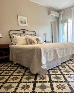 a bedroom with a large bed with a patterned floor at Finca El Maitén. Posada Boutique in San Rafael