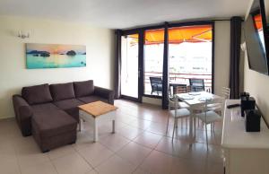 een woonkamer met een bank en een tafel bij Seaview apartment near the beach in Playa de las Americas