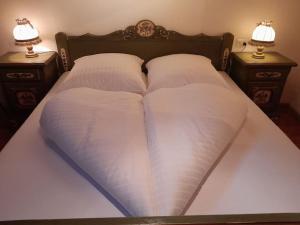 a bed with two pillows and two night stands at Schlernwohnung in Seis am Schlern in Siusi +5 photos