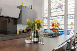 a kitchen with a table with a bottle of wine and flowers at Modern & Spacious 2 bed Apartment By The Sea, free parking, wifi, netflix in Teignmouth