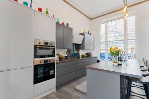 a kitchen with stainless steel appliances and a table at Modern & Spacious 2 bed Apartment By The Sea, free parking, wifi, netflix in Teignmouth