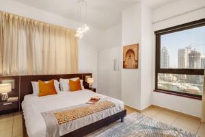a bedroom with a bed and a large window at Luxe, spacious, 2BD Condo with Full kitchen, Marina View, Steps from JBR Beach, Tram & Marina by "La Buena Vida Holiday Homes" in Dubai