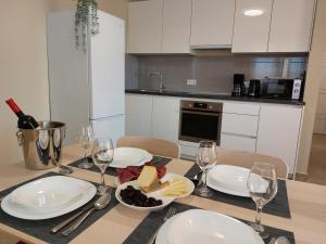 stół z talerzami jedzenia i kieliszkami do wina w obiekcie Seashells Apartments Tribunj w mieście Tribunj