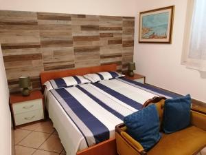 アルゲーロにあるVilla con piscina "Su Conte"のベッドルーム(ベッド1台、ソファ付)