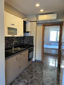 a kitchen with a sink and a stove at Ninve Apartments – Istanbul Bakirköy in Istanbul
