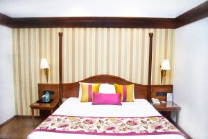 a bed in a hotel room with two night stands at Shervani Hilltop Resort in Nainital