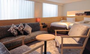 a hotel room with a couch and a bed at HOTEL RINGS KYOTO in Kyoto