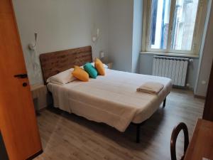 a bedroom with a white bed with colorful pillows at Hotel Big Bang in Rome