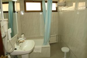 
a bathroom with a toilet, sink and tub at Hotel Bilbaino in Benidorm
