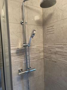 a shower with a shower head in a bathroom at Gated home close to Birmingham City Centre in Birmingham