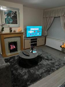 a living room with a fireplace and a television at Gated home close to Birmingham City Centre in Birmingham