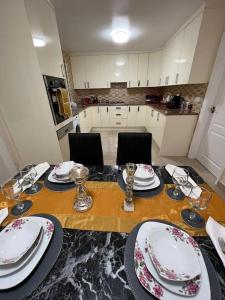 a dining room table with plates and dishes on it at Gated home close to Birmingham City Centre in Birmingham