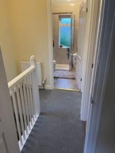 a hallway with a staircase leading to a bathroom at Gated home close to Birmingham City Centre in Birmingham