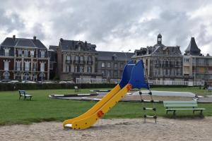 um escorrega amarelo e azul num parque com edifícios em Le Horsier em Dieppe