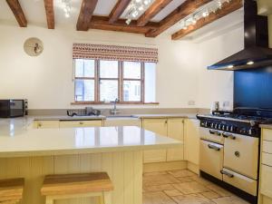 a kitchen with a white counter top and a stove at Colstey Farmhouse in Acton