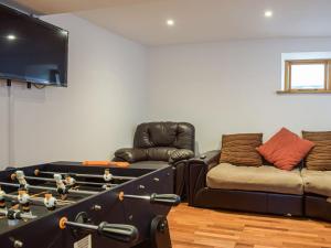 a living room with a pool table and a couch at Colstey Farmhouse in Acton