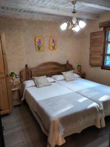 a bedroom with two large beds with white sheets at VUT El Pajariel Ponferrada in Ponferrada