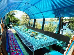 una mesa larga con un mantel azul. en Asfandiar Hotel, en Karakol