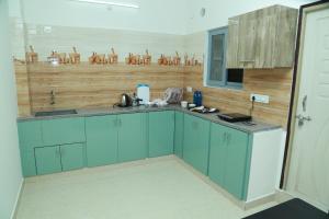 a kitchen with blue cabinets and a wooden wall at Ameya Homestays Brand New Fully Furnished 3BHK & 2BHK Apartments. in Tirupati