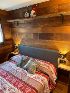 Un dormitorio con una pared de madera y una cama en Baita del Cervino CIR n 0016, en Breuil-Cervinia