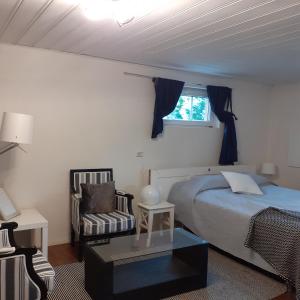 una camera con un letto e una sedia e una finestra di Room in Villa Emilia a Espoo