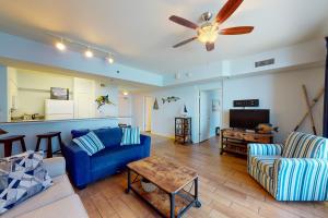 a living room with a blue couch and a table at Shores of Panama 1615 in Panama City Beach