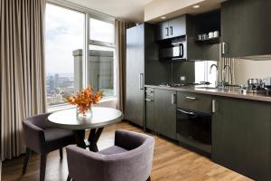 a kitchen with a dining room table and a large window at One King West Hotel and Residence in Toronto