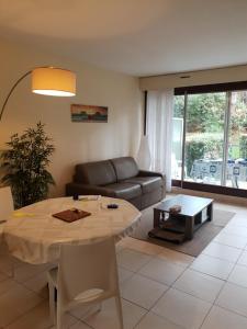 a living room with a table and a couch at Appartement standing front de mer Arcachon in Arcachon
