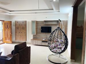 a living room with a chair and a swing at Ameya Homestays Brand New Fully Furnished 3BHK & 2BHK Apartments. in Tirupati