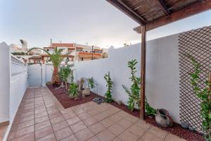 an outdoor patio with plants and a white wall at Marvelous holiday home - villa La Caleta in Adeje