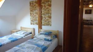 1 dormitorio con 2 camas y espejo en Felső Fogadó en Felsőtold