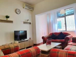 a living room with couches and a flat screen tv at Lovely Two Bedroom Apartment in Amman in Umm Uthainah