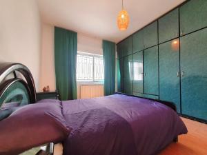 a bedroom with a purple bed and green cabinets at Lovely Two Bedroom Apartment in Amman in Umm Uthainah