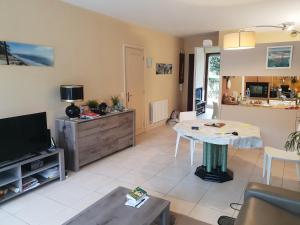 a living room with a tv and a table at Appartement standing front de mer Arcachon in Arcachon