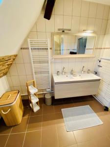 uma casa de banho com um lavatório e um espelho em L'Envolée Alsacienne - Magnifique appartement en duplex em Ostheim
