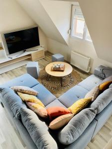 - un salon avec un canapé bleu et des oreillers dans l'établissement L'Envolée Alsacienne - Magnifique appartement en duplex, à Ostheim