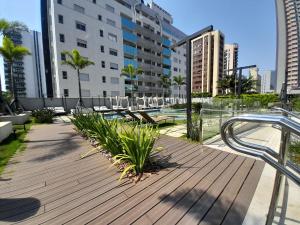 a wooden deck with chairs and a pool in a city at Locking's Funcionários 1 in Belo Horizonte