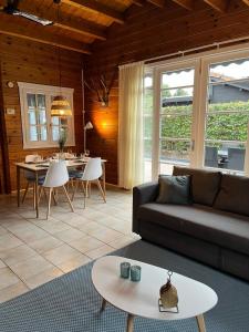 sala de estar con sofá y mesa en Veluwse Bungalow en Ermelo