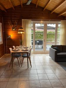 een woonkamer met een tafel en een bank bij Veluwse Bungalow in Ermelo