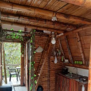 una cocina con una pared de madera y una escalera en una casa en Cabañas Camino al Agua - Cocorná, en San Francisco