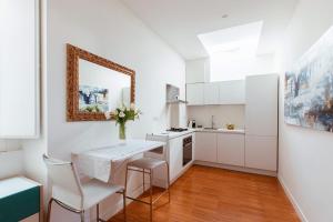 a kitchen with white cabinets and a table and chairs at Cobalto Suite in Campobasso