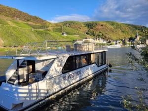 Ein Boot liegt auf einem Fluss im Wasser. in der Unterkunft KL Moselboote - Hausboot Niara in Bernkastel-Kues