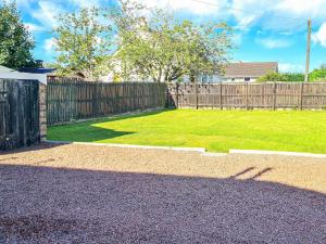 威蕭的住宿－Kirklea，后院设有木栅栏和绿色草坪