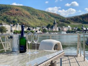 una botella de vino y dos copas de vino sentadas en una mesa en KL Moselboote - Hausboot Niara, en Bernkastel-Kues