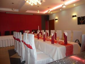 a long table with white chairs and red napkins at Guest House Penzión Fortuna in Tvrdošín